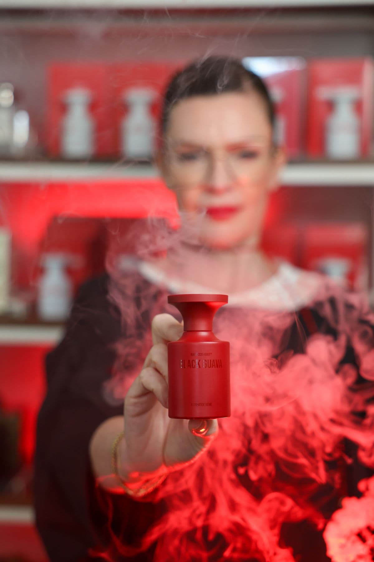 Ritratto editoriale con profumo rosso e fumo scenografico