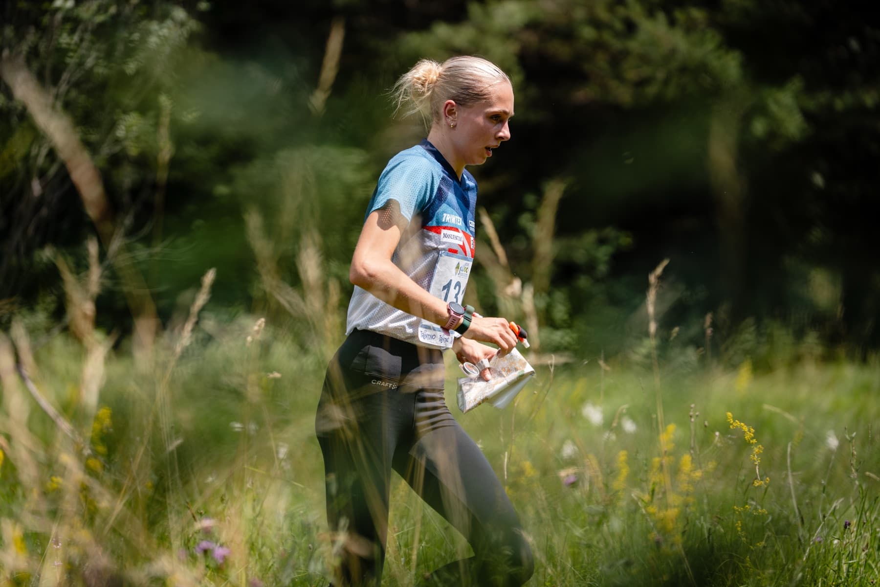 Atleta di orienteering tra i prati del Trentino