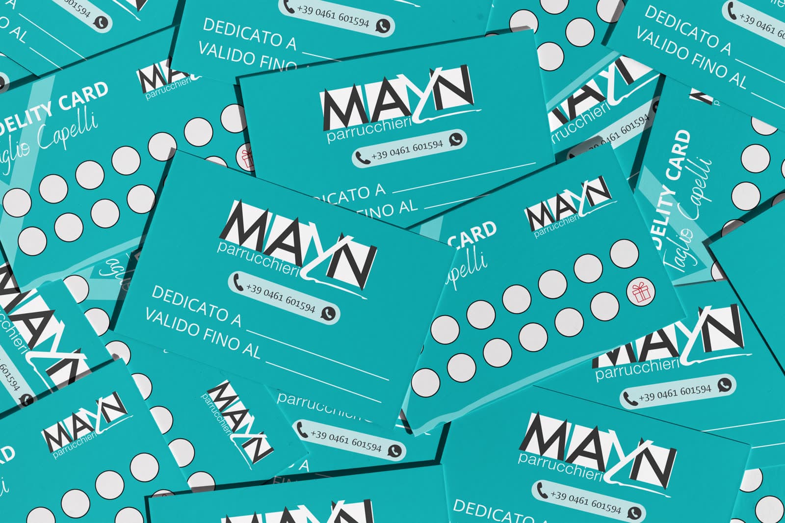 Le fidelity card Mayn sparse, teal e bianche, con il logo e i timbri delle visite